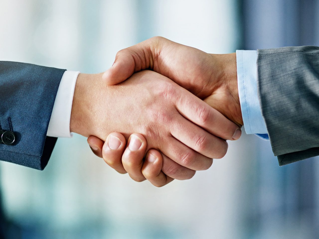 Closeup shot of two businessmen shaking hands in an office